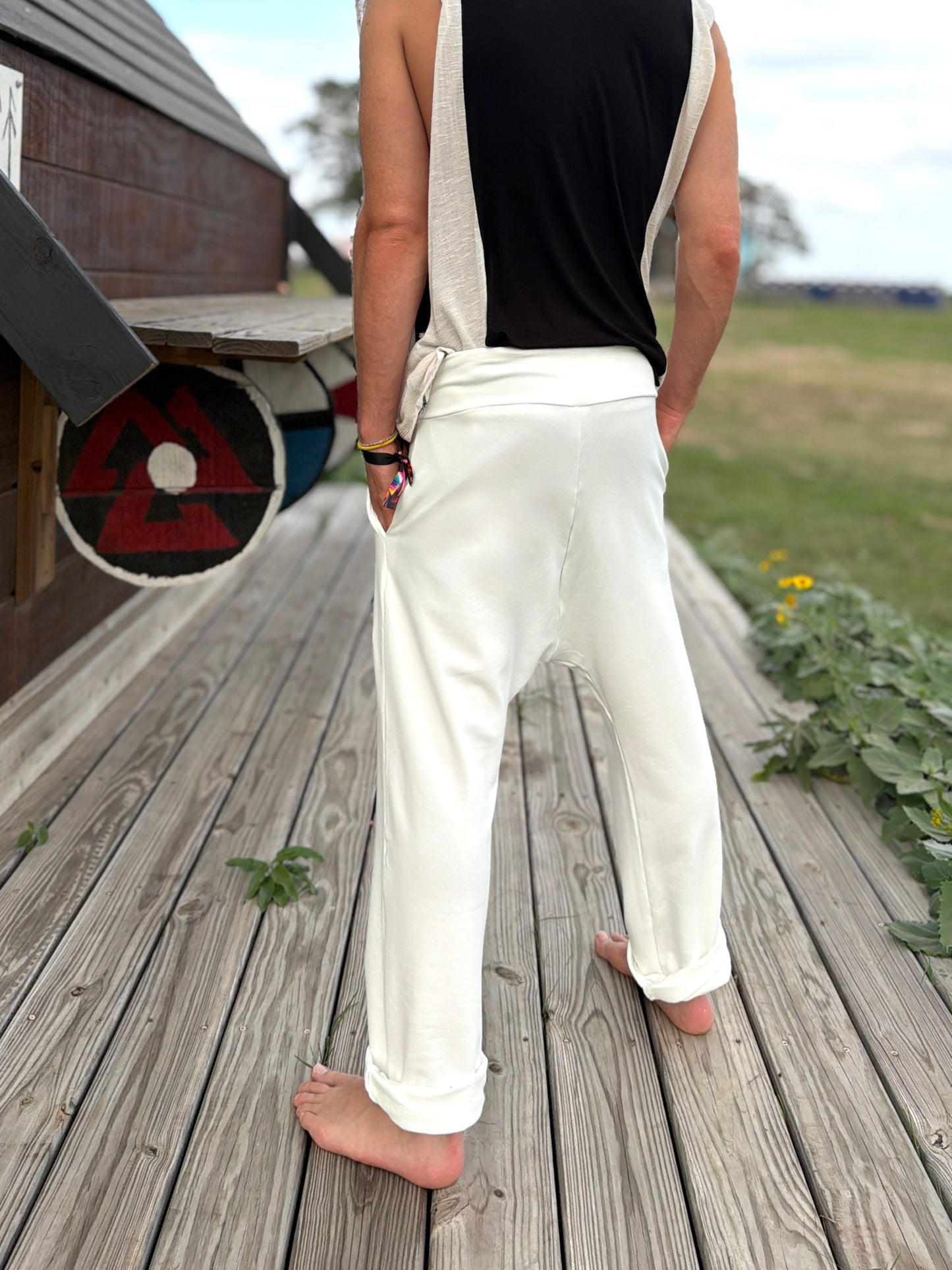 Person wearing glorka white Tom pants standing on a wooden deck.