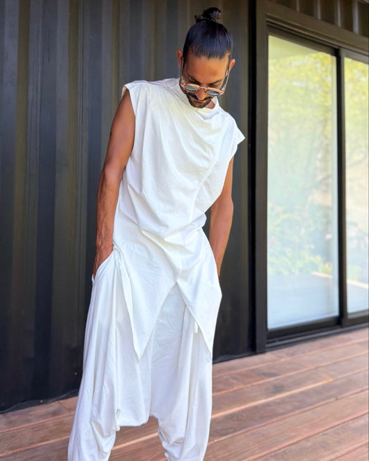 Person wearing a white outfit standing on a wooden deck.