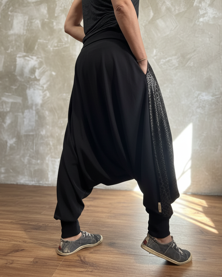 Person wearing a black glorka outfit standing against a textured wall.