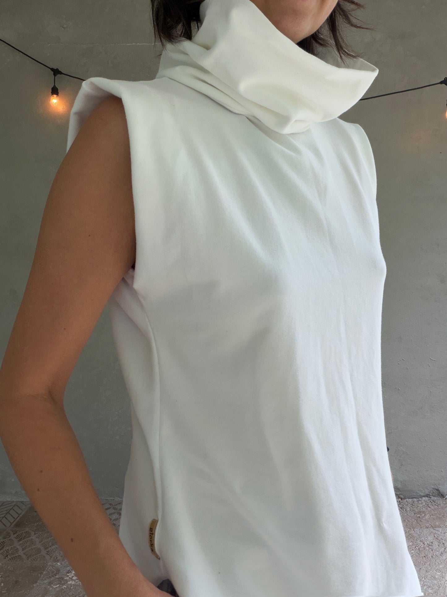 Female model wearing glorka white top with turtle neck