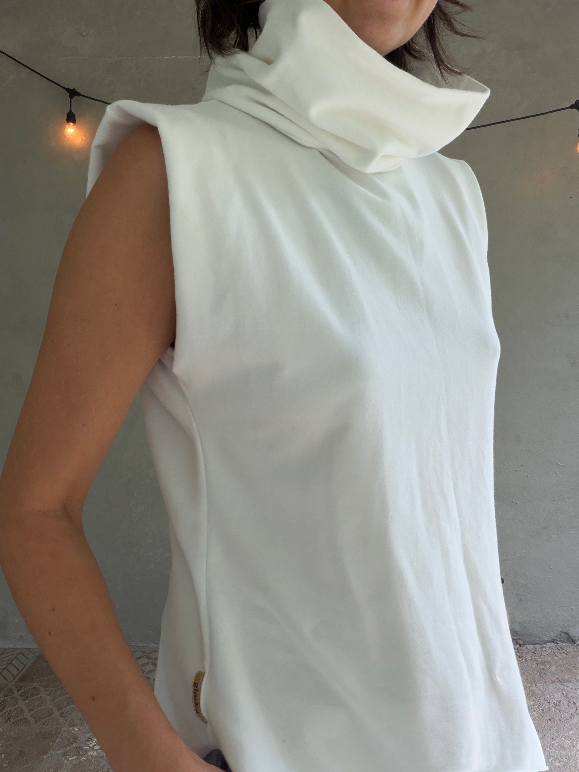 Female model wearing glorka white top with turtle neck