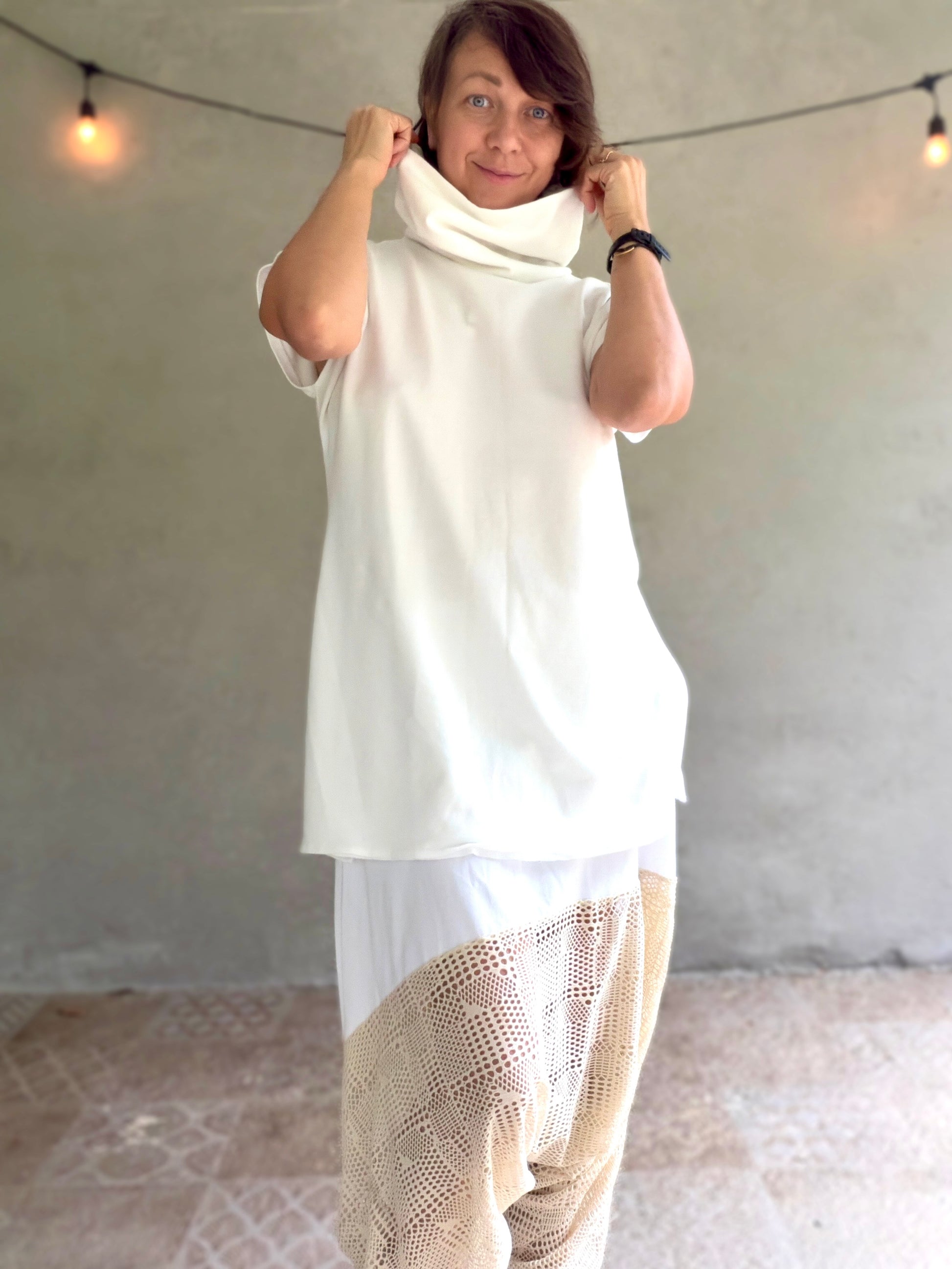 Female model wearing glorka white top with turtle neck