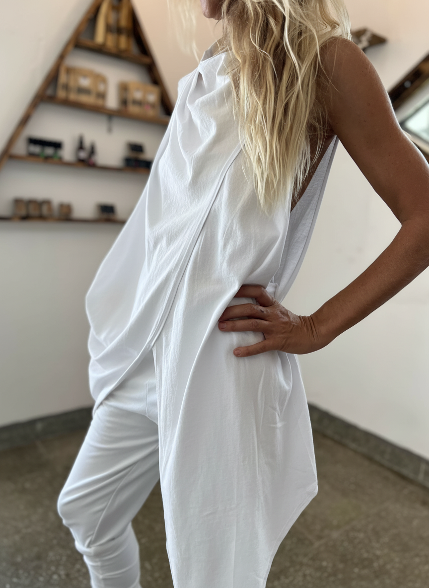 Person wearing a white outfit in an indoor setting with shelves in the background