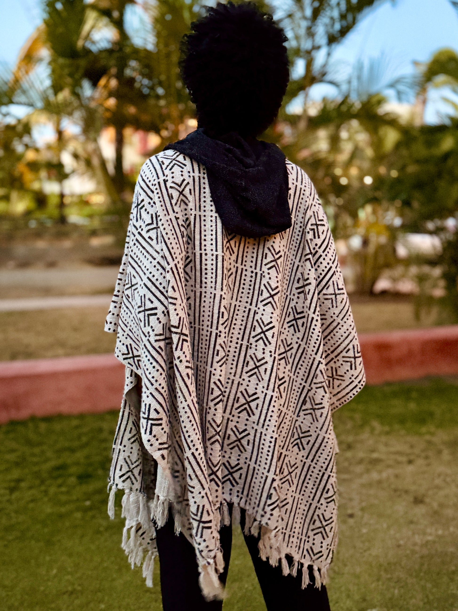a man standing in glorka handblock printed poncho with dark gray hood
