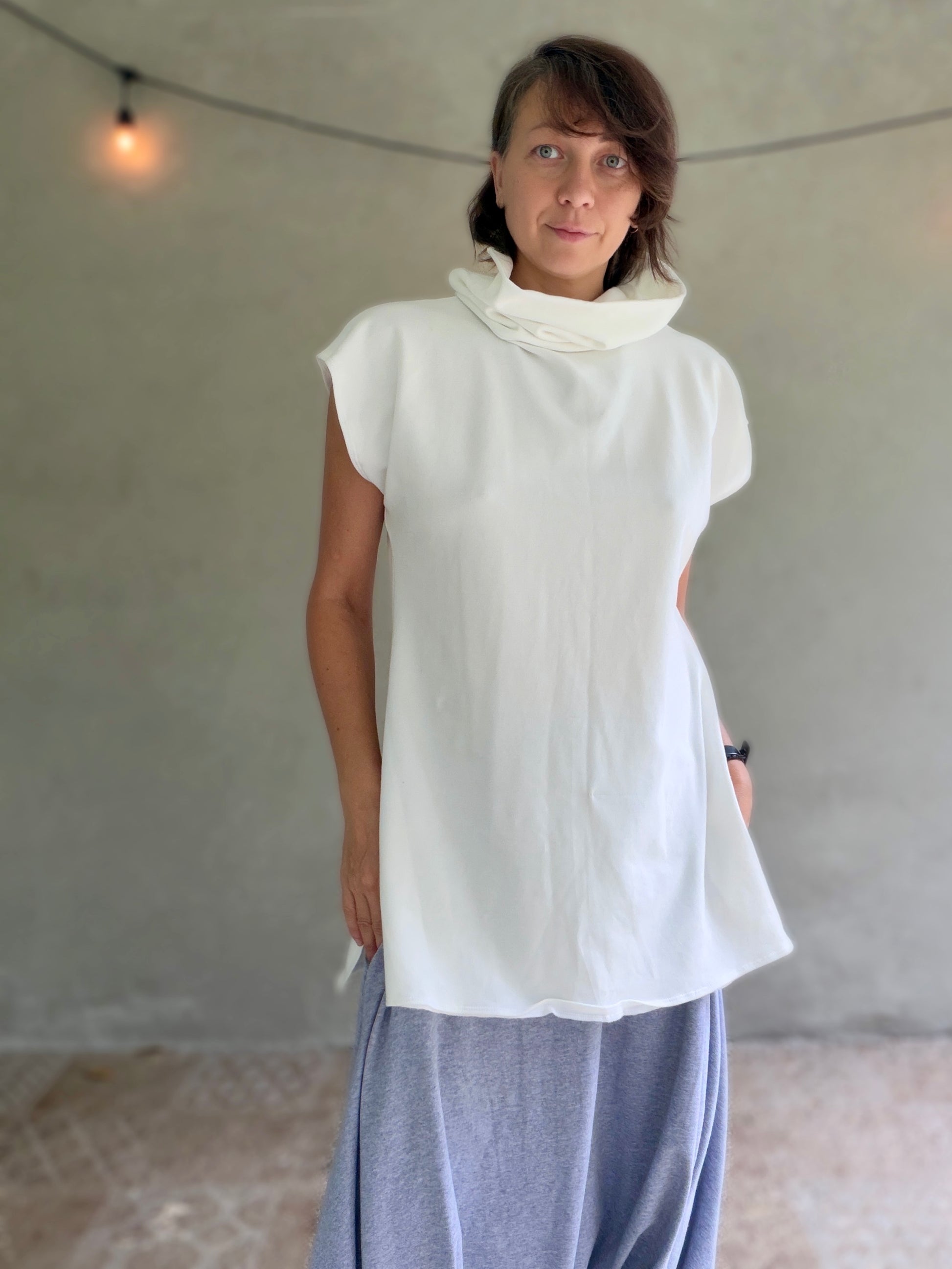 Female model wearing glorka white top with turtle neck