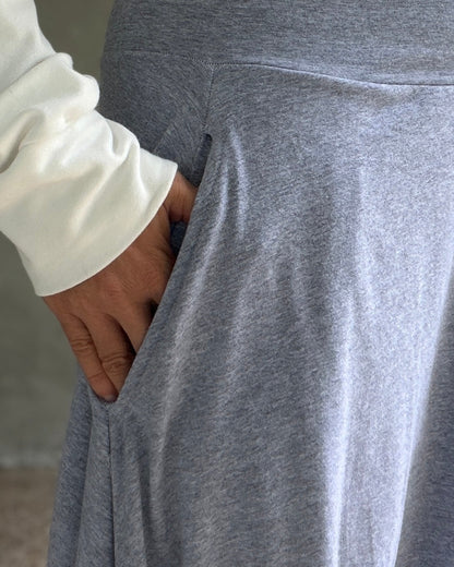 Person wearing a gray pants and has her hand in the pocket