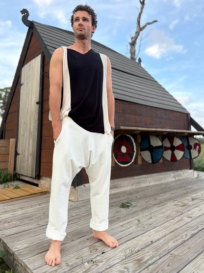 Person wearing glorka white Tom pants standing on a wooden deck.