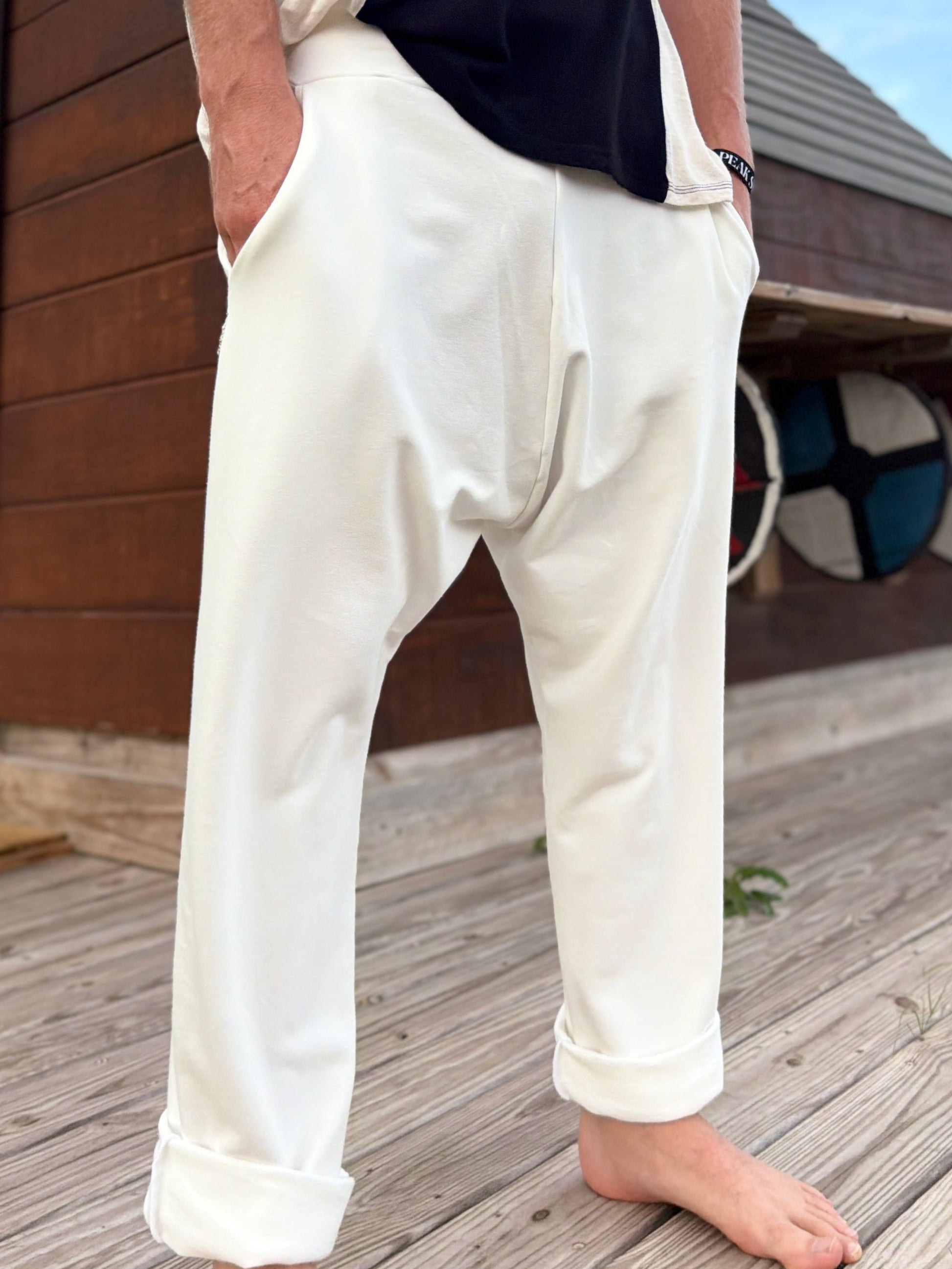 Person wearing glorka white Tom pants standing on a wooden deck.