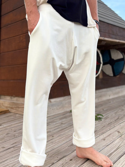 Person wearing glorka white Tom pants standing on a wooden deck.
