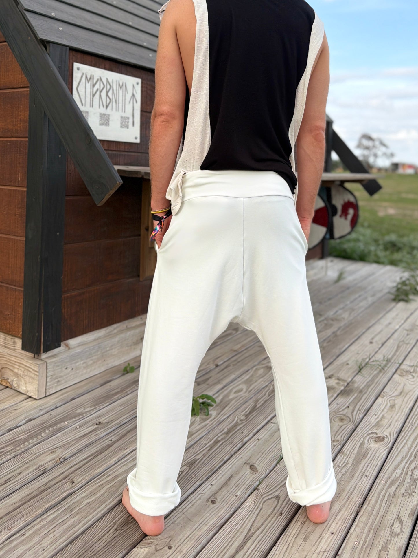 Person wearing glorka white Tom pants standing on a wooden deck.