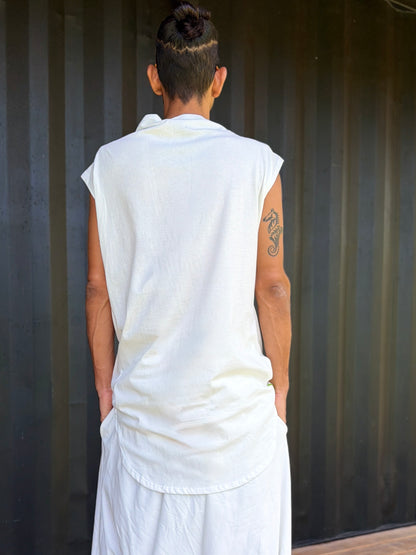 Person wearing a white organic cotton glorka jedi top outfit against a corrugated metal background