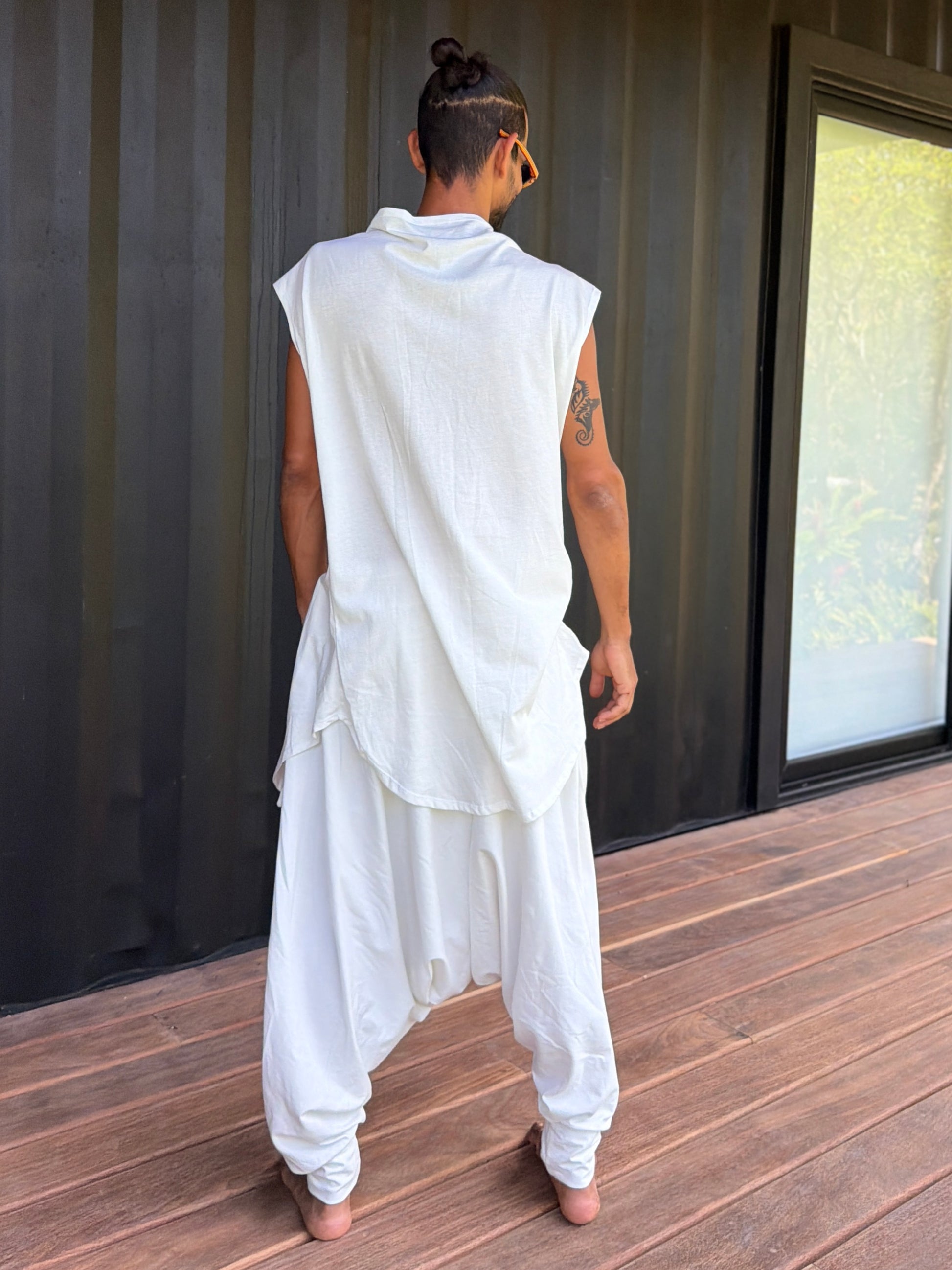 Person wearing a white organic cotton glorka outfit against a corrugated metal background