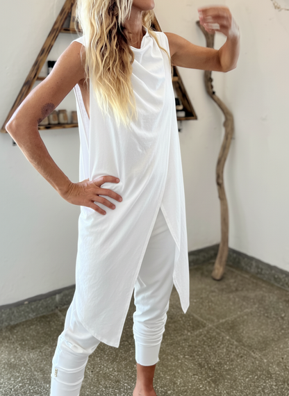 Person wearing a white outfit in an indoor setting with minimal decor.