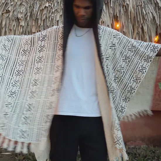 a man dancing wearing glorka handblock printed poncho with dark gray hood