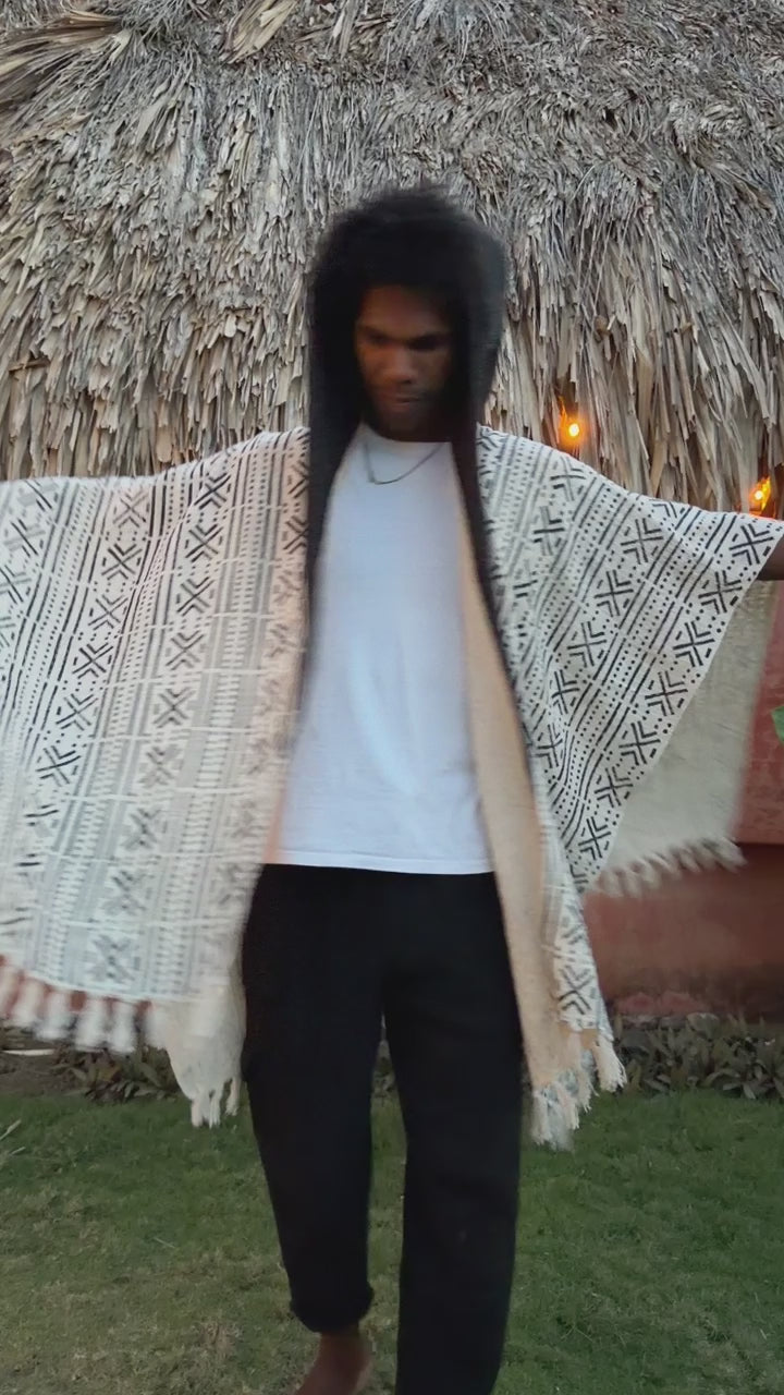 a man dancing wearing glorka handblock printed poncho with dark gray hood
